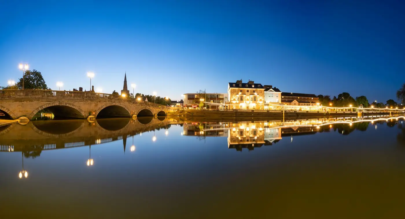 Bedford town bridge and the River Great Ouse illuminated at dusk